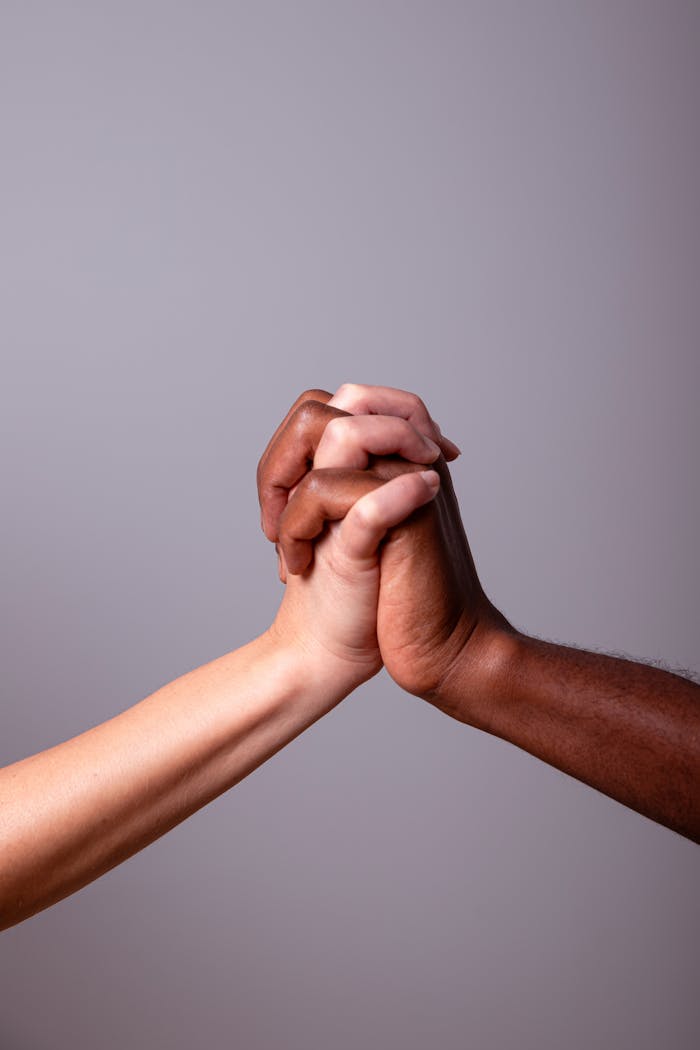 Two hands clasped in unity symbolizing diversity and inclusion.